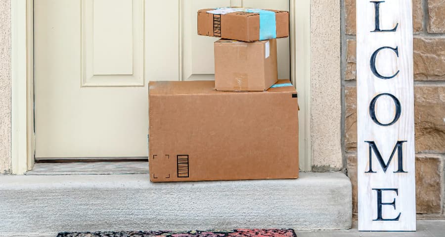 Packages on the doorstep of a home with a welcome sign in Santa Clarita